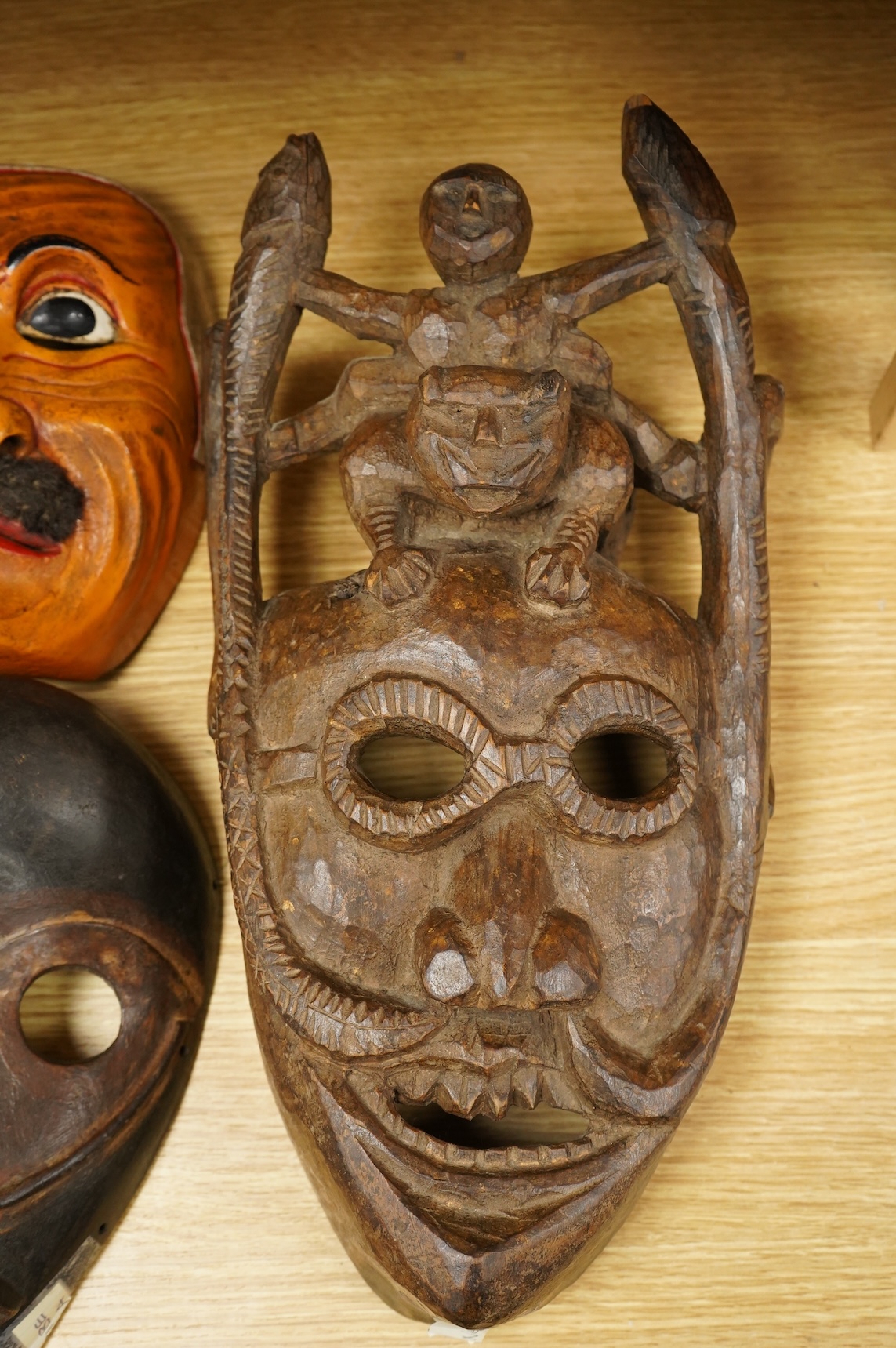 A collection of seven Nepalese, African and Indonesian masks to include a Magar example and one from the Dan Tribe, Liberia, largest 40cm